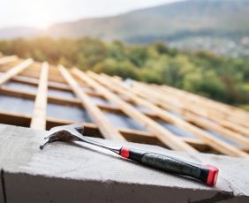 Hammer on the roof on the construction site.